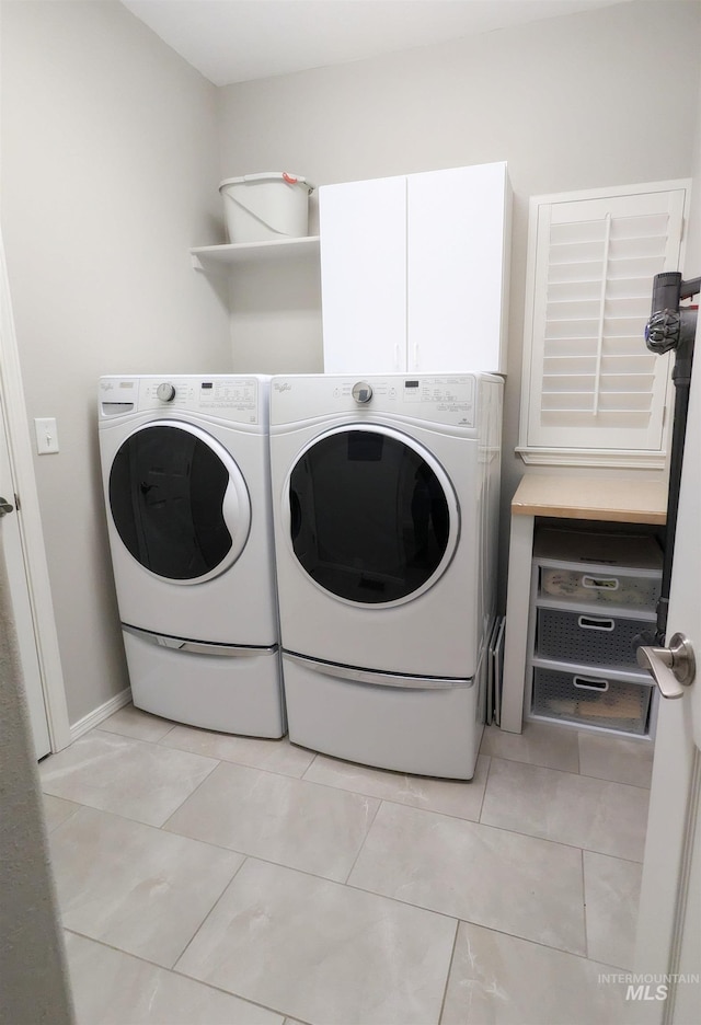 washroom with cabinets, independent washer and dryer, and light tile patterned floors