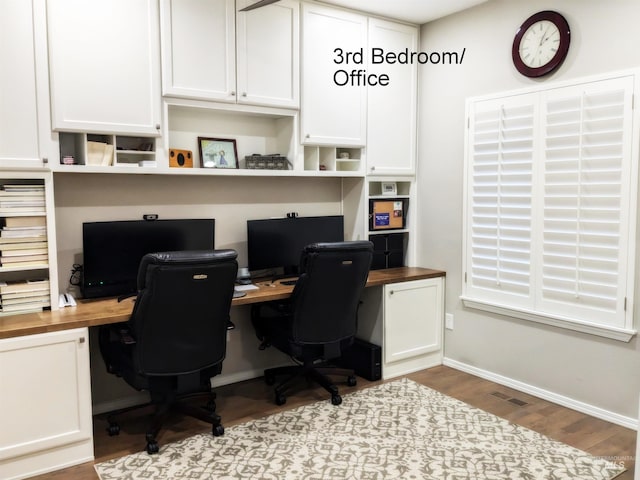 home office featuring built in desk and hardwood / wood-style flooring