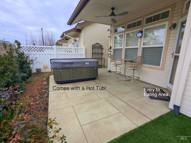 view of patio with ceiling fan and a hot tub