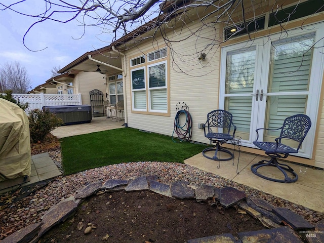 rear view of property featuring a patio area and a hot tub