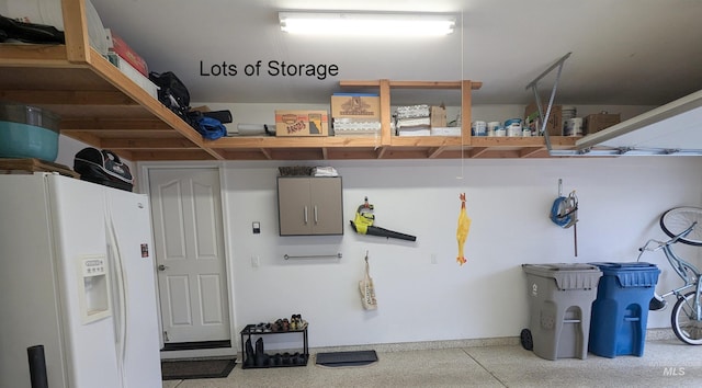 garage featuring white fridge with ice dispenser