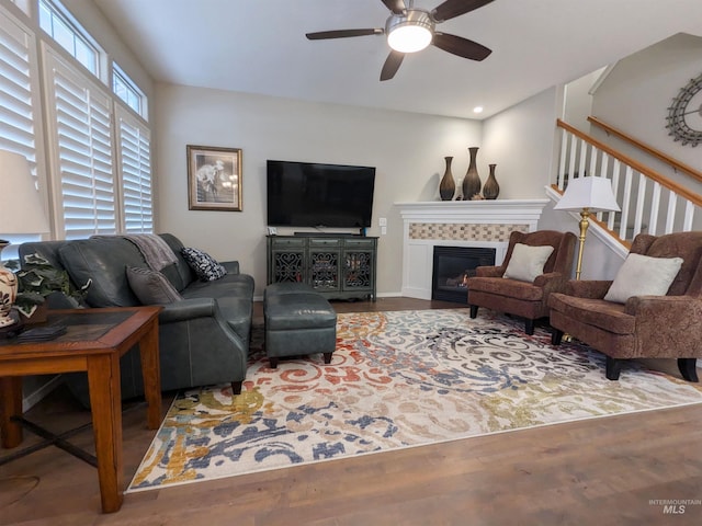 living room featuring ceiling fan, a fireplace, and hardwood / wood-style floors