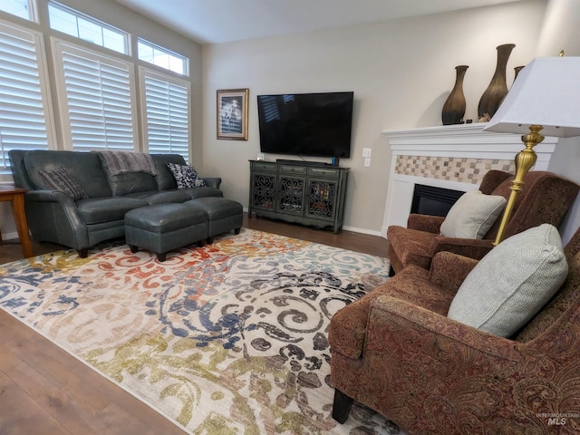 living room with a tile fireplace and hardwood / wood-style flooring