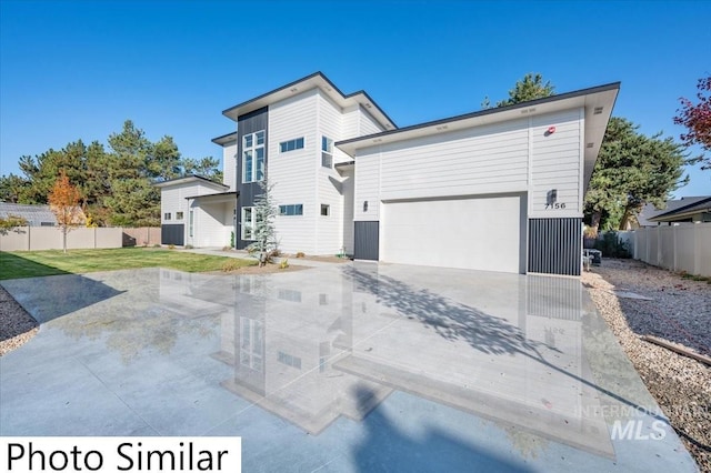 exterior space featuring a garage, driveway, and fence