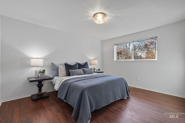 bedroom with dark wood-type flooring