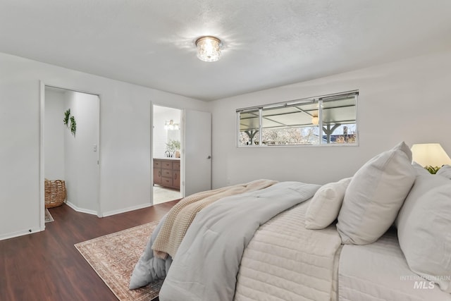 bedroom with ensuite bathroom, dark hardwood / wood-style flooring, and a textured ceiling