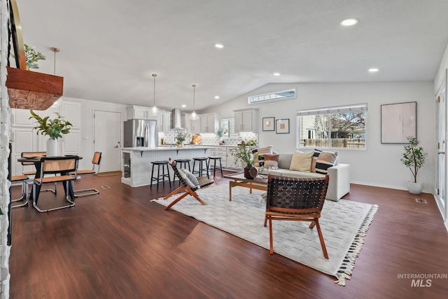 living room featuring dark wood-type flooring and vaulted ceiling