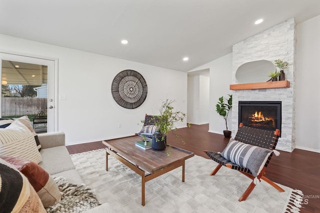 living room with a fireplace, light hardwood / wood-style floors, and vaulted ceiling