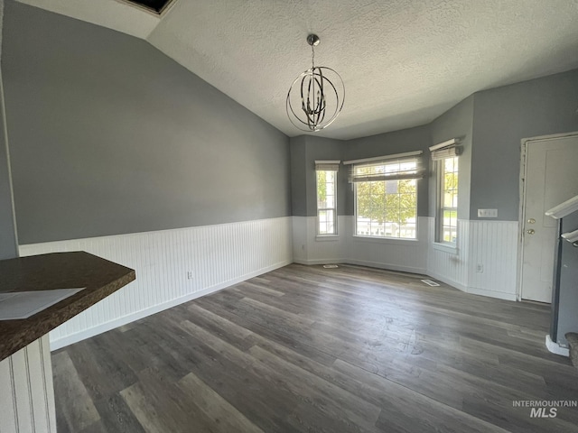 3915 N Abbott St, Caldwell, ID 83607 - unfurnished dining area with a wainscoted wall, a chandelier, dark wood-style floors, vaulted ceiling, and a textured ceiling