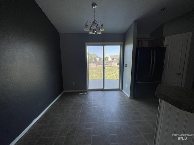 3915 N Abbott St, Caldwell, ID 83607 - unfurnished dining area with baseboards, a chandelier, and vaulted ceiling