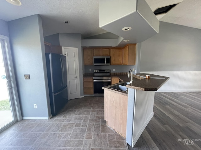 3915 N Abbott St, Caldwell, ID 83607 - kitchen with appliances with stainless steel finishes, a sink, a peninsula, baseboards, and a textured ceiling