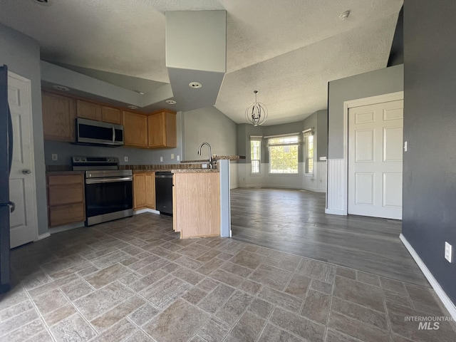 3915 N Abbott St, Caldwell, ID 83607 - kitchen with stainless steel appliances, open floor plan, baseboards, a peninsula, and a textured ceiling