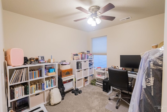 carpeted office space with ceiling fan