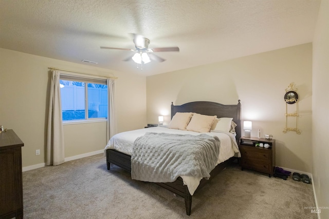 carpeted bedroom featuring a textured ceiling and ceiling fan