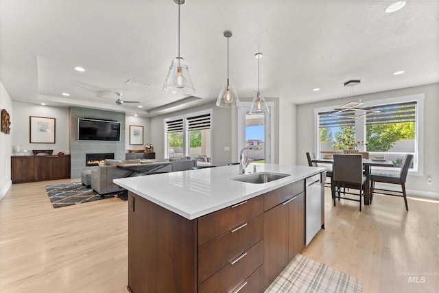 kitchen featuring a sink, light wood-style floors, recessed lighting, light countertops, and an island with sink