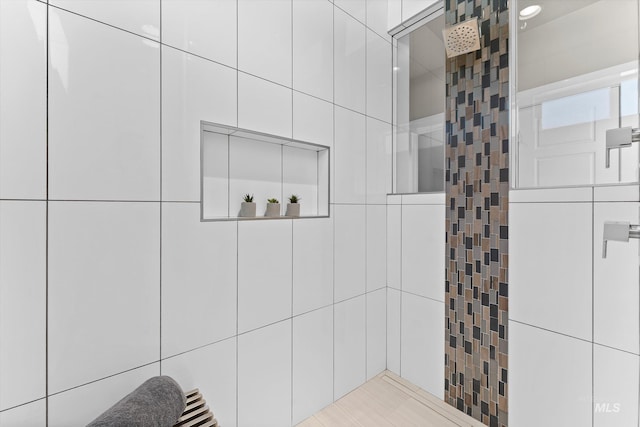 full bath with tiled shower and tile walls