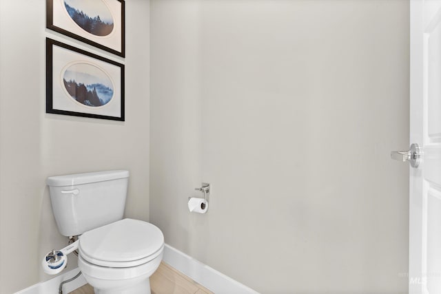 bathroom featuring baseboards and toilet
