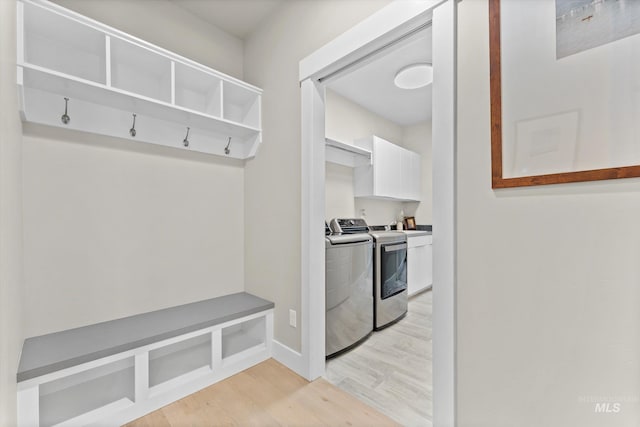 mudroom featuring washer and dryer, light wood finished floors, and baseboards