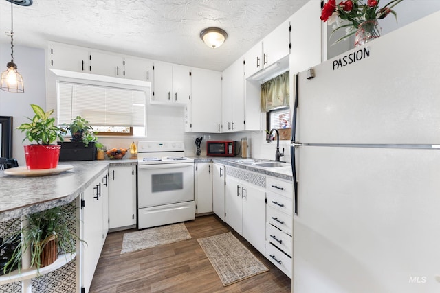 kitchen with white appliances, dark wood-type flooring, a sink, white cabinets, and decorative backsplash