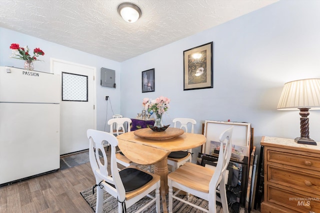 dining room with a textured ceiling and wood finished floors