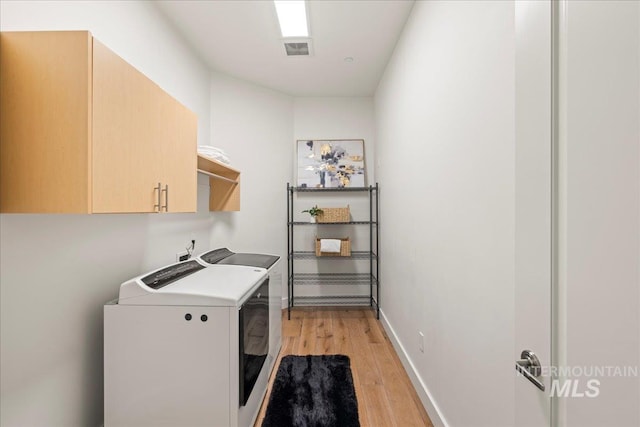 1112 W Main St Unit 503, Boise, ID 83702 - laundry area featuring washing machine and clothes dryer, cabinet space, and light wood-style flooring
