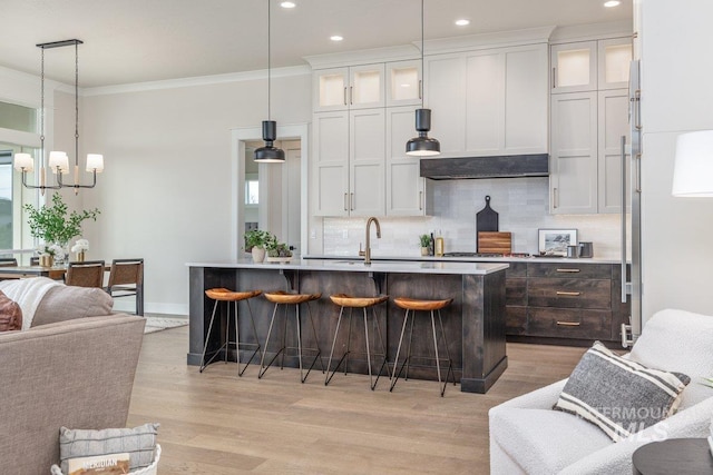 kitchen with decorative backsplash, a breakfast bar, a chandelier, white cabinetry, and recessed lighting