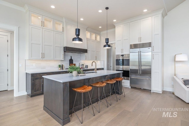 kitchen featuring stainless steel appliances, backsplash, baseboards, light wood-style floors, and recessed lighting
