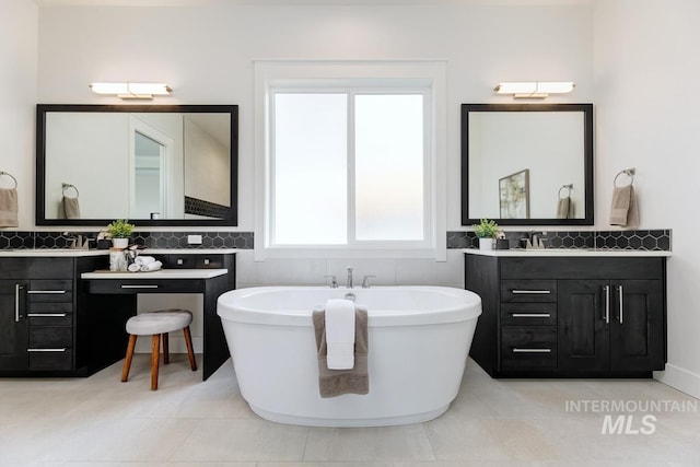 full bath featuring a freestanding tub, two vanities, and tile patterned floors