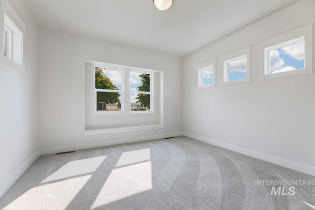 carpeted empty room with baseboards