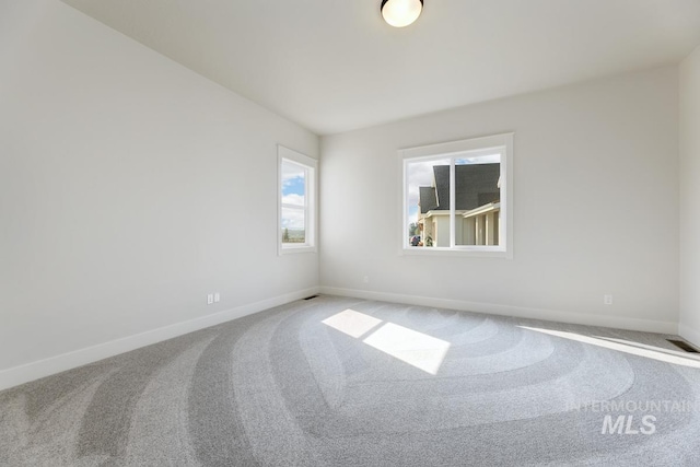 spare room with carpet and baseboards