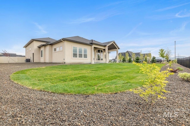 rear view of house featuring stucco siding and central AC