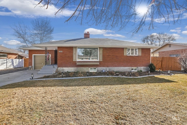 view of front of property with fence, brick siding, driveway, and a chimney