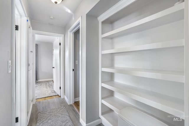 hall with baseboards and wood finished floors