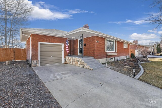 single story home with driveway, fence, a garage, brick siding, and a chimney