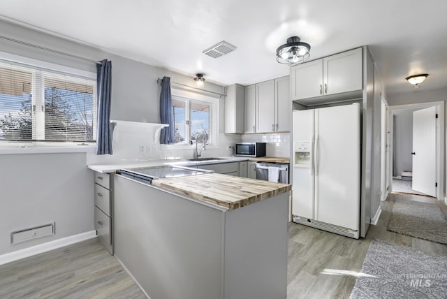 kitchen with visible vents, backsplash, gray cabinetry, appliances with stainless steel finishes, and a sink