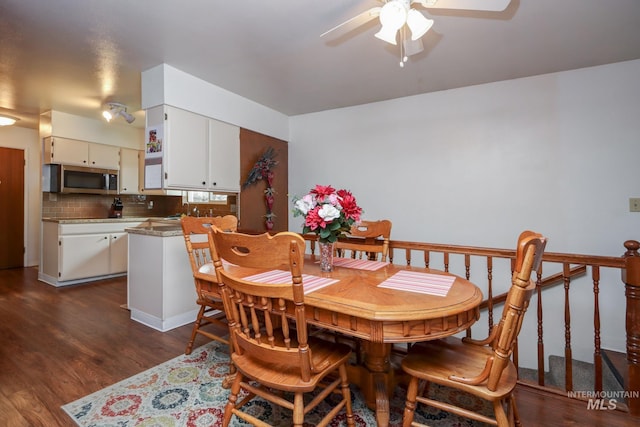 dining space with dark wood-type flooring and ceiling fan