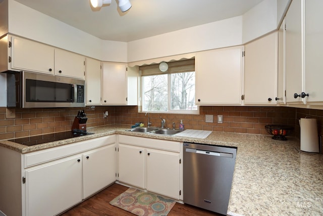 kitchen with a sink, light countertops, backsplash, and stainless steel appliances