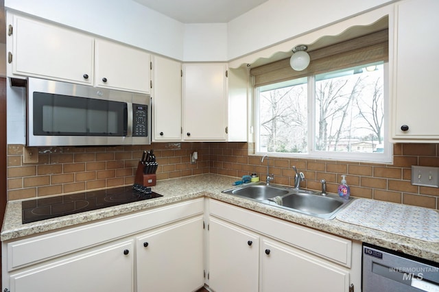 kitchen with light countertops, tasteful backsplash, appliances with stainless steel finishes, and a sink