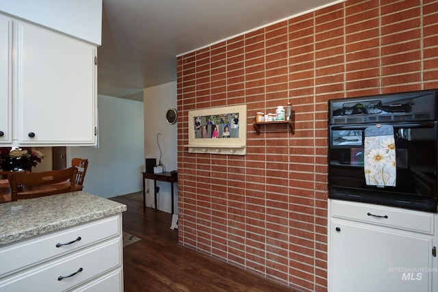 kitchen with white cabinets, dark wood-style floors, and oven