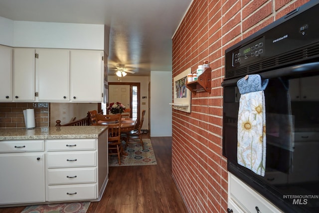 kitchen with a ceiling fan, dark wood finished floors, oven, decorative backsplash, and white cabinetry