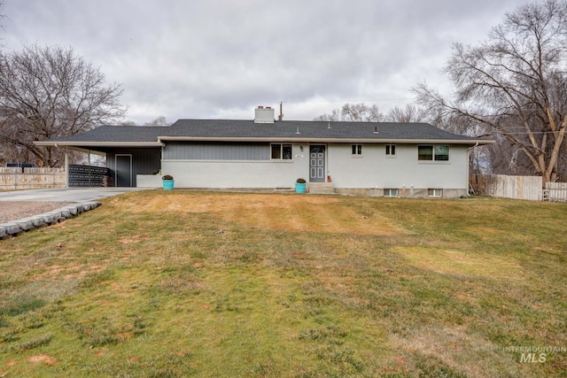 ranch-style house featuring a carport, fence, a front yard, and a chimney