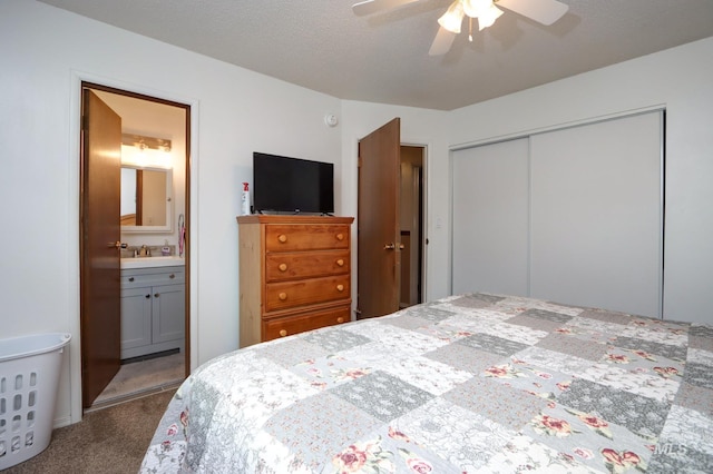 bedroom with a textured ceiling, ensuite bath, a closet, carpet floors, and ceiling fan