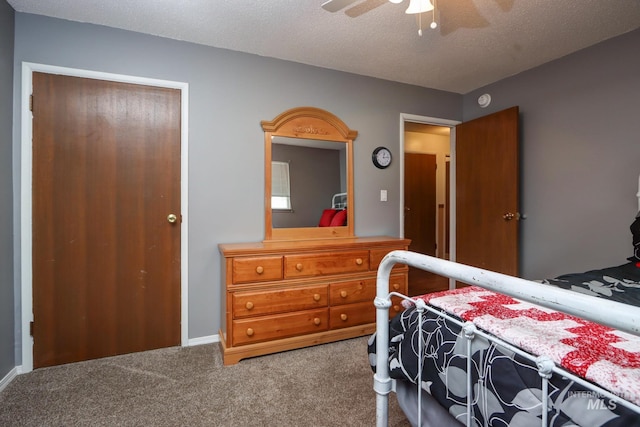 carpeted bedroom with a textured ceiling and a ceiling fan