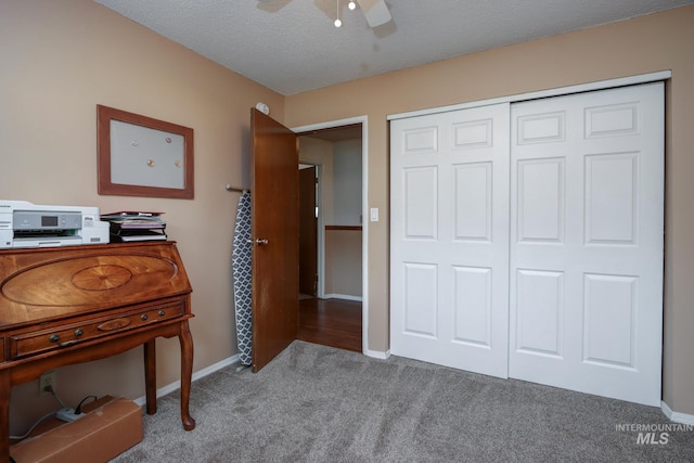 unfurnished bedroom featuring a ceiling fan, baseboards, a closet, a textured ceiling, and carpet flooring