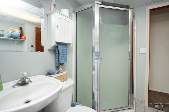 full bath featuring toilet, a stall shower, and a sink