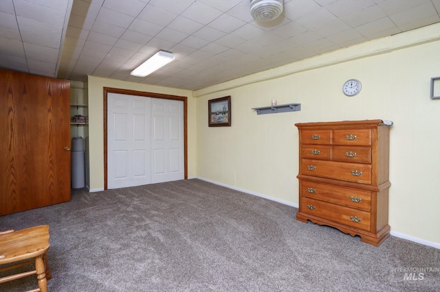 unfurnished bedroom with carpet flooring, baseboards, and a closet