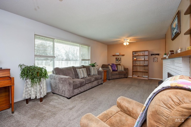 carpeted living area featuring ceiling fan, a fireplace, baseboards, and a textured ceiling