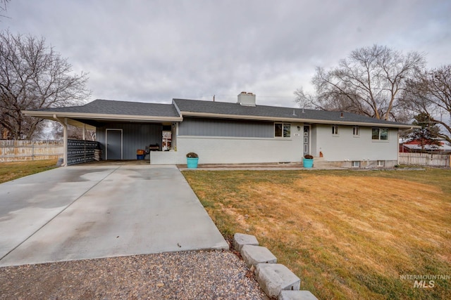 view of front of house featuring concrete driveway, a front yard, and fence