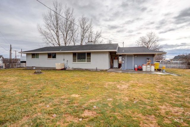 back of house featuring a patio, fence, a lawn, and a chimney