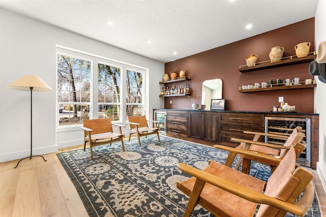 bar with wine cooler and light wood-type flooring